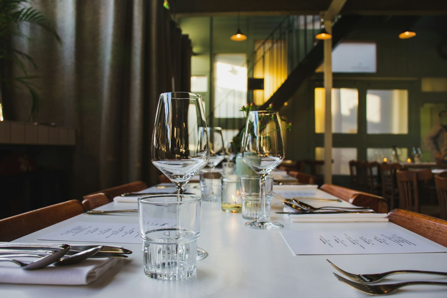 Set table with glasses and menus waiting for guests in a restaurant