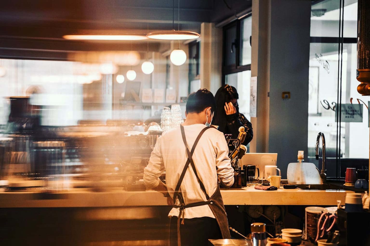 Staff working behind a cafe counter during evening service