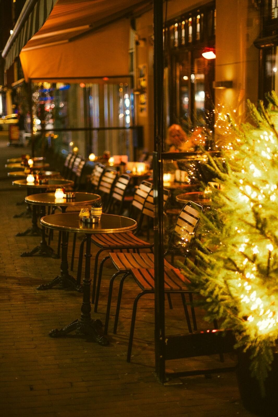 Restaurant terrace tables with candles on an old town street in the evening